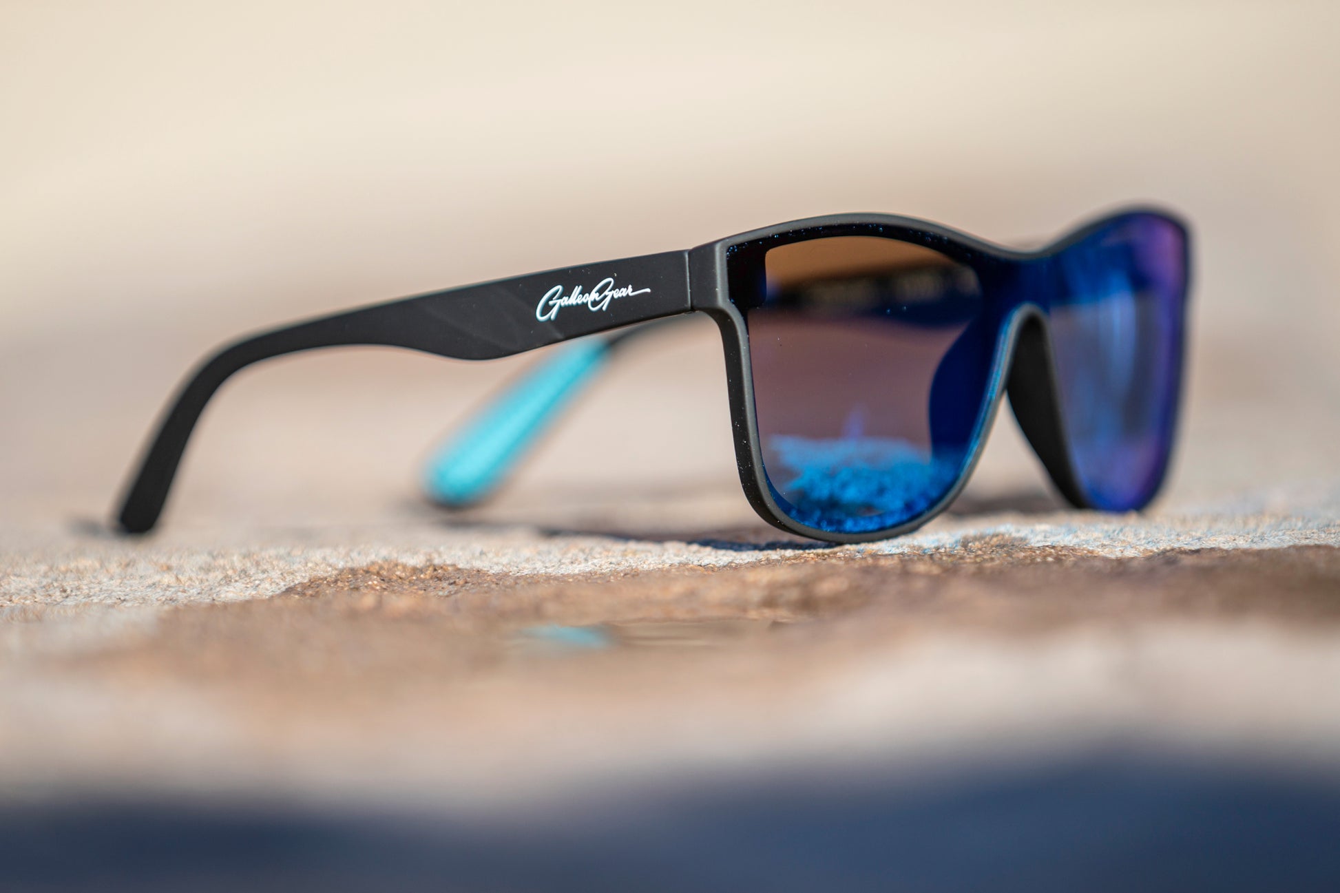 Sunglasses with blue lenses and black frame on a blurred background