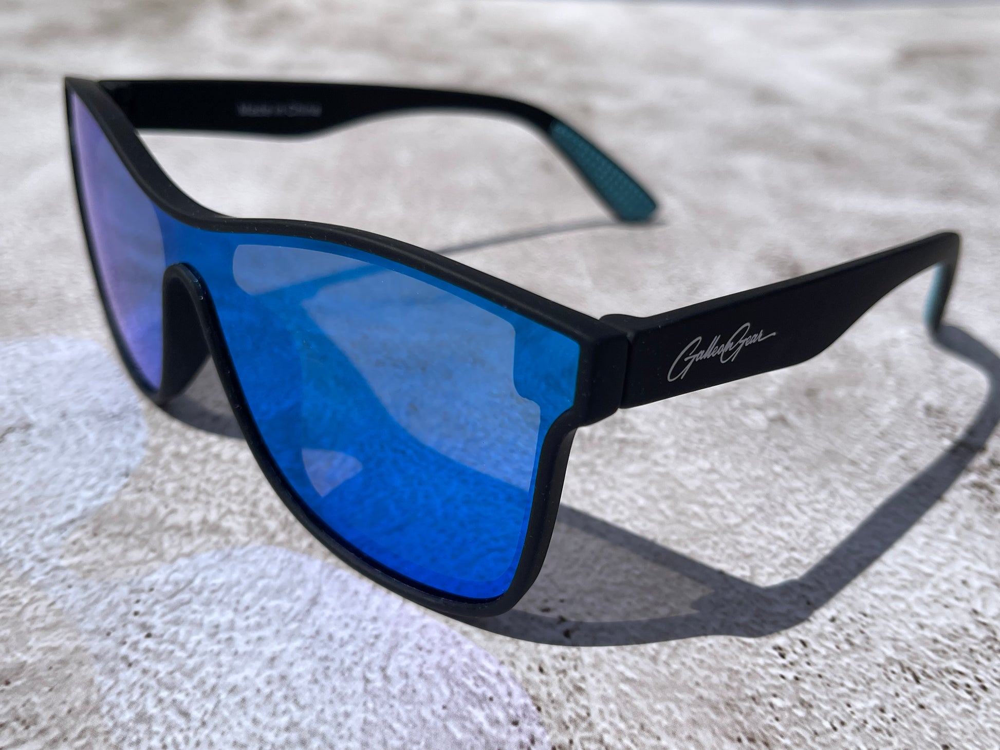 Black sunglasses with blue lenses on a textured surface